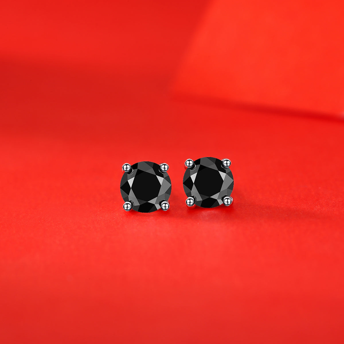 Tree of Life Studio black mosan diamond stud earrings with round black diamonds on red background