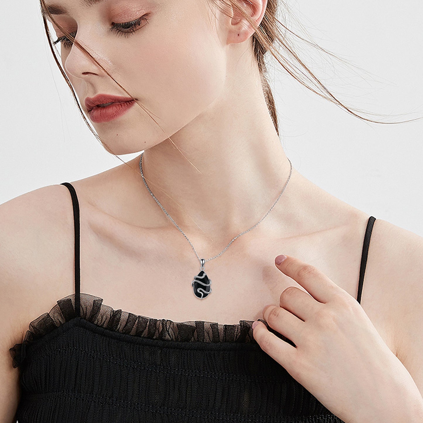 Tree of Life Studio black obsidian snake necklace worn by woman with black top