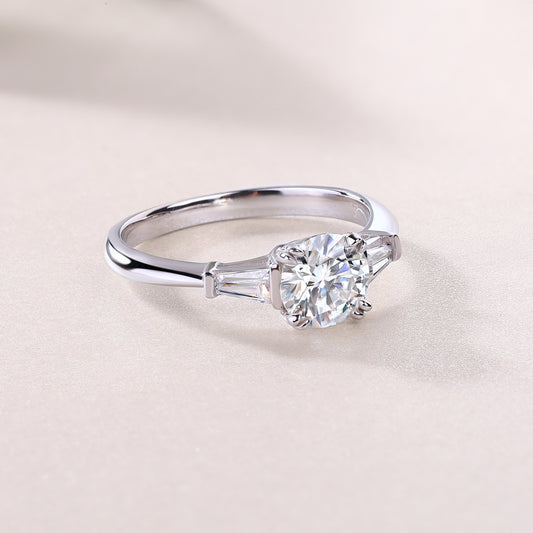 Classic Moissanite silver engagement ring with a round center stone and tapered baguette side stones