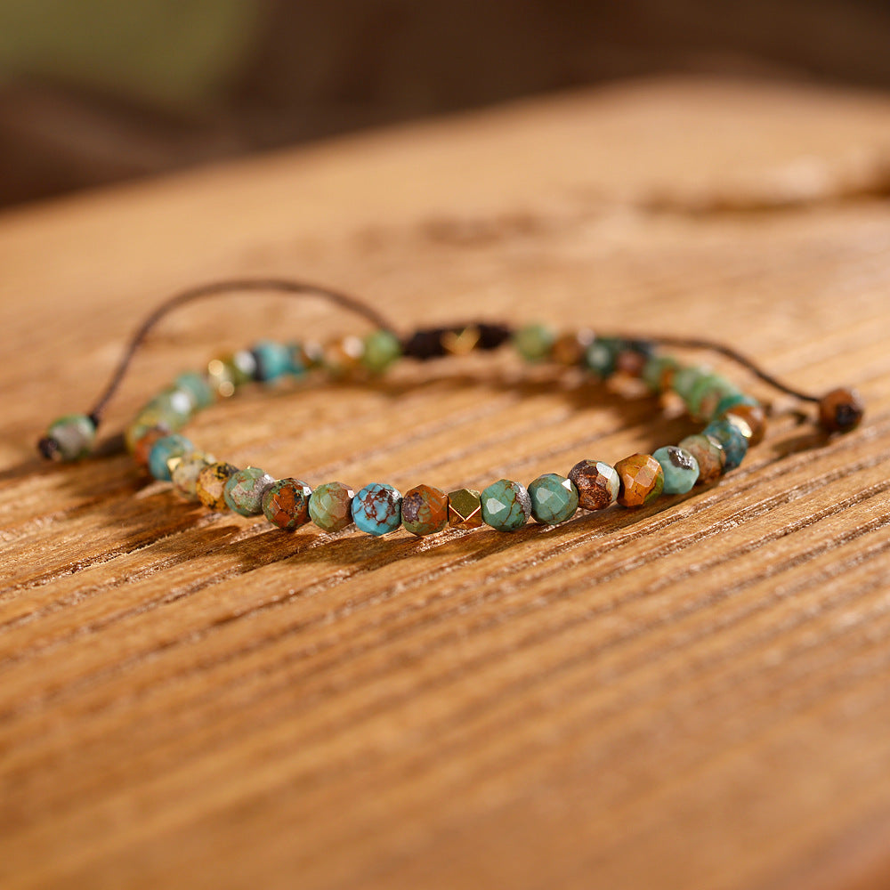 Natural African turquoise handmade bracelet with green and brown beads on wooden surface