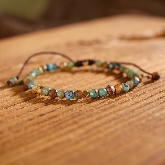 Natural African turquoise handmade bracelet with green and brown beads on wooden surface