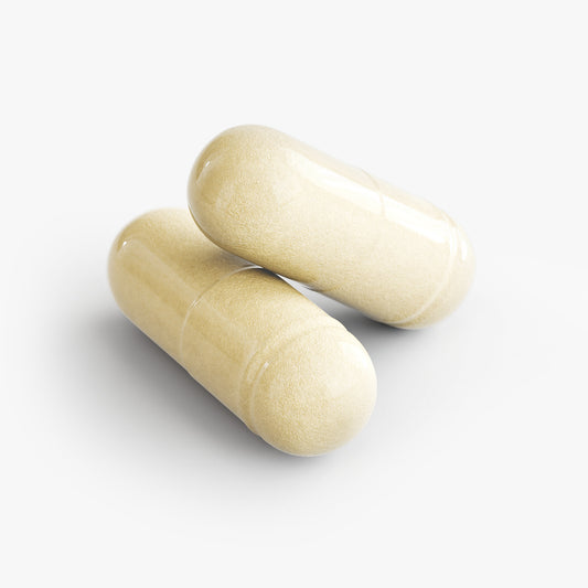 Two beige capsules of Tree of Life Studio premium brain support supplement on a white background