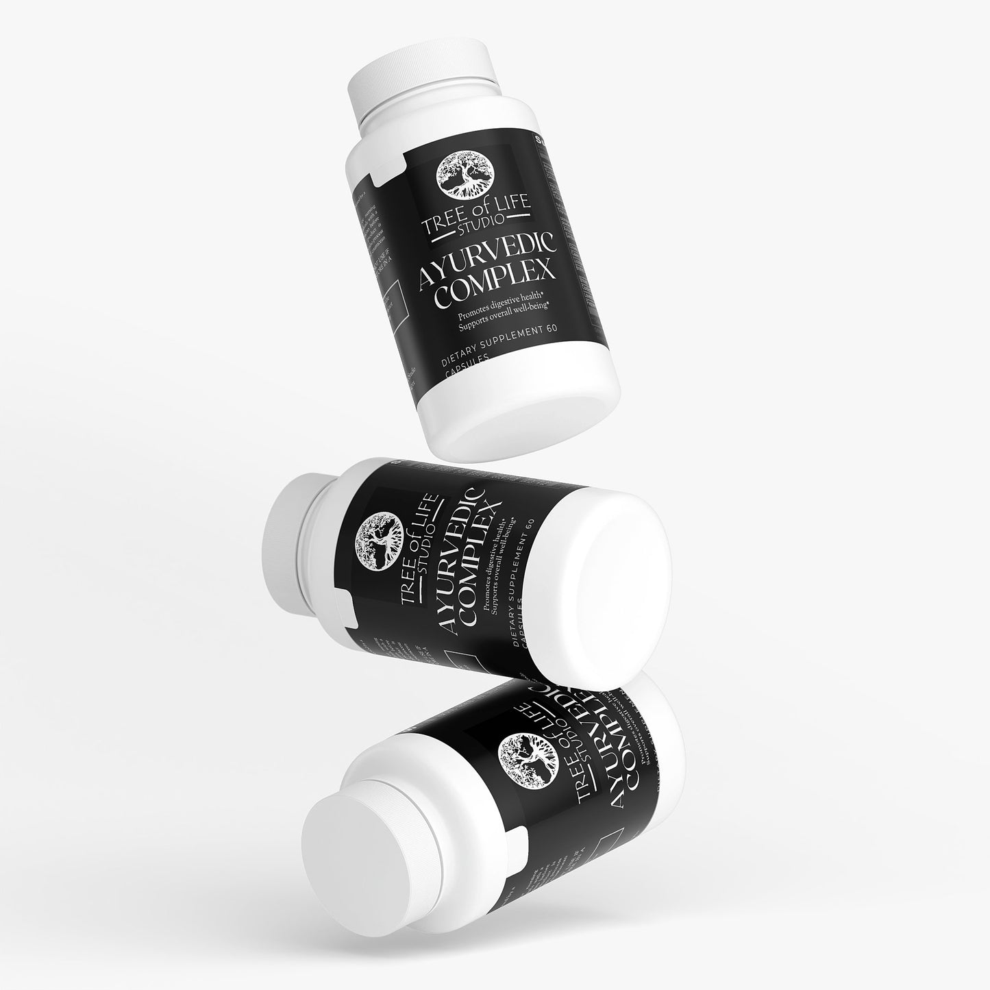 Three white bottles of Tree of Life Studio ayurvedic supplement complex with black labels floating on white background