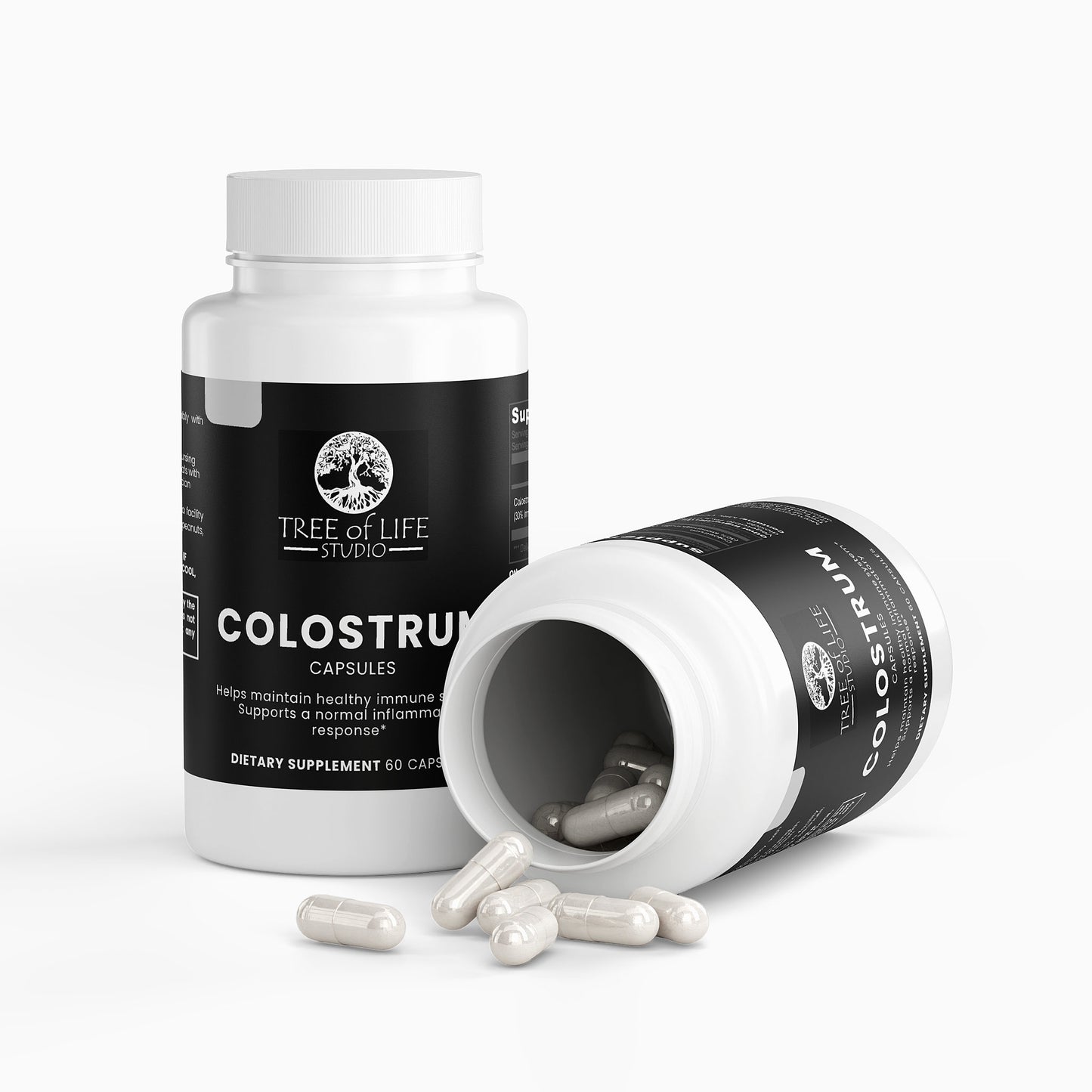 Tree of Life Studio premium colostrum supplement capsules in white bottles with some capsules spilled