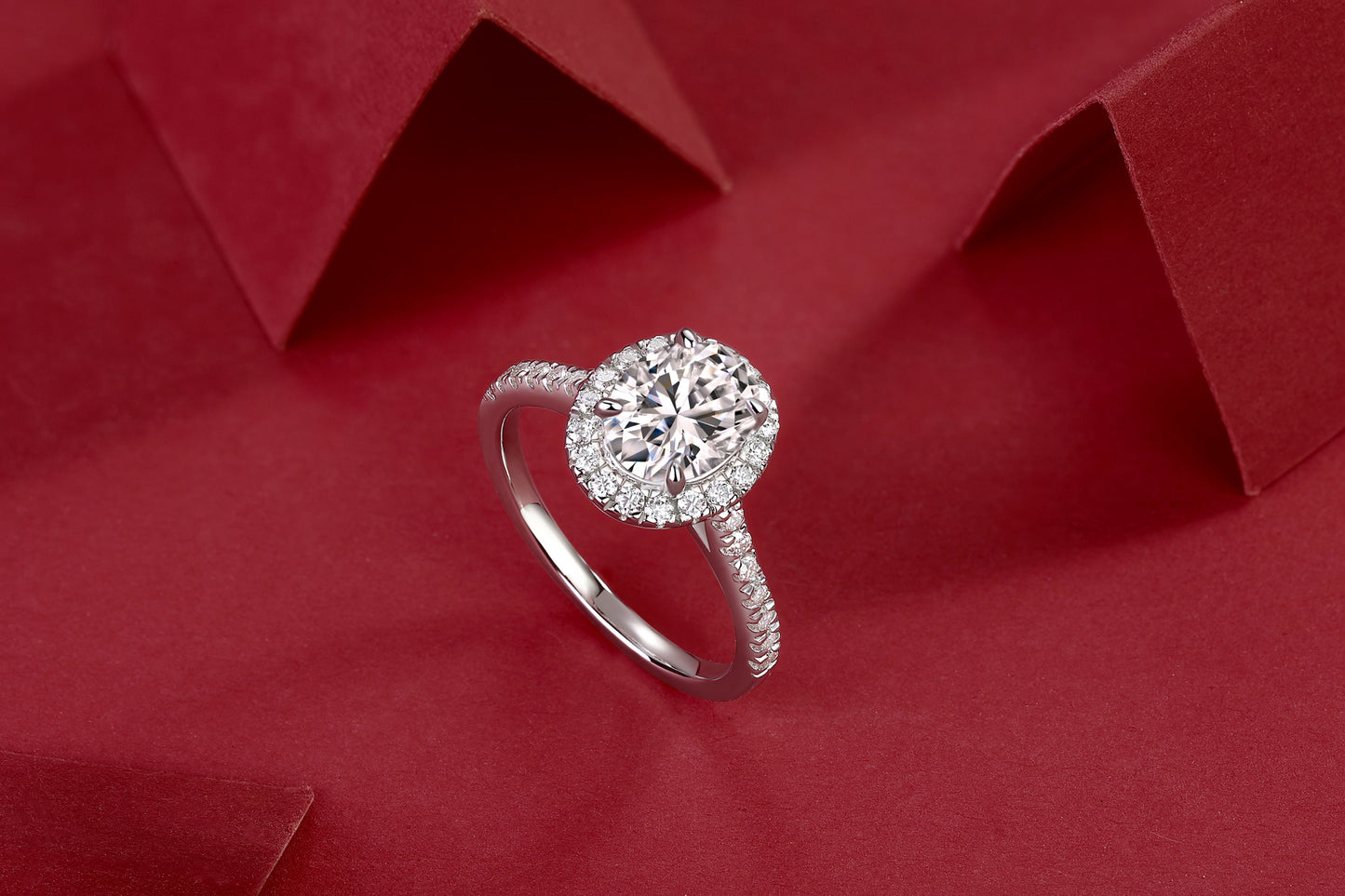Tree of Life Studio large moissanite halo ring with sparkling center stone and pave band on red background