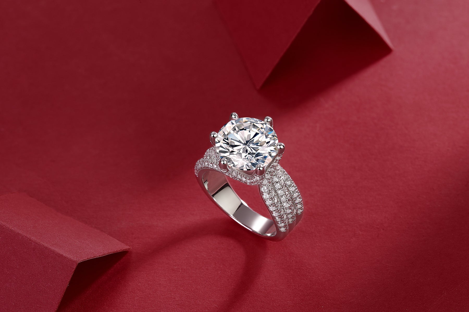 Large silver moissanite ring with multiple small sparkling stones and intricate band design
