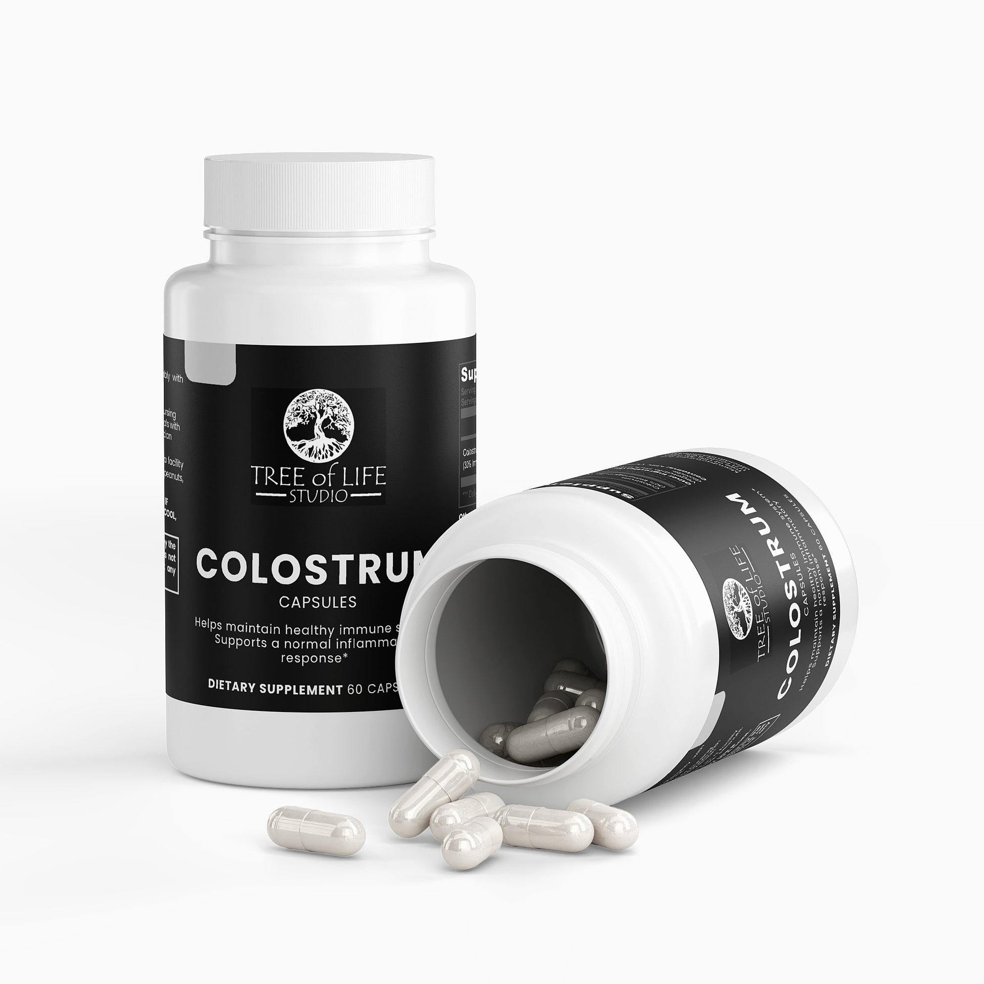 Tree of Life Studio premium colostrum supplement capsules in white bottles with some capsules spilled