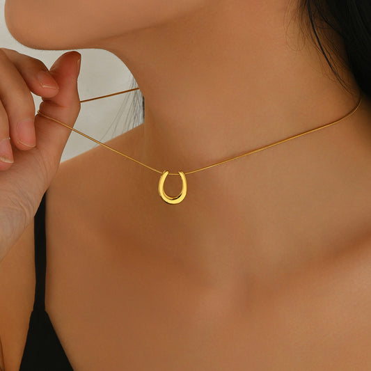 18K gold horseshoe necklace by Tree of Life Studio worn on woman’s neck with delicate chain