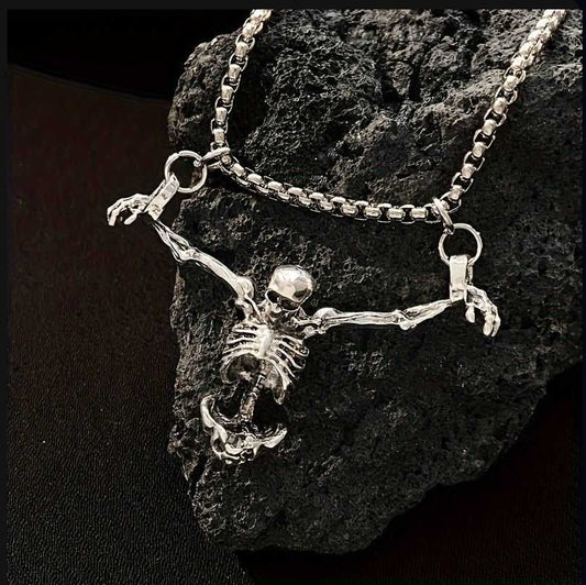Tree of Life Studio silver spiritual skeleton necklace with outstretched arms on black rock background